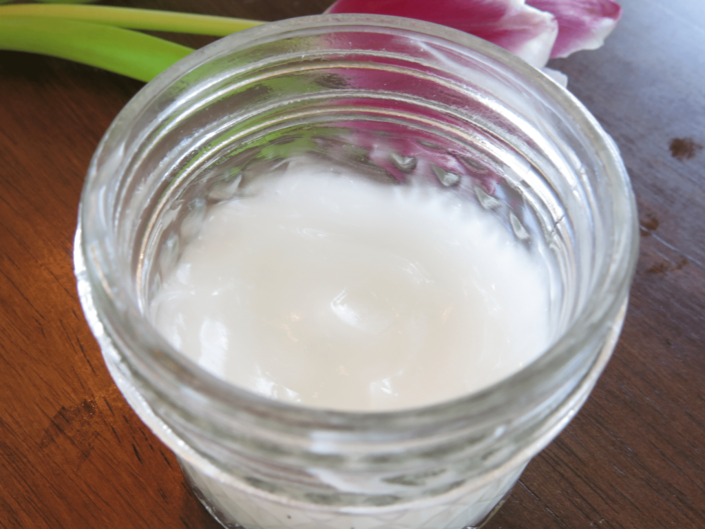DIY face moisturizer in glass jar on table