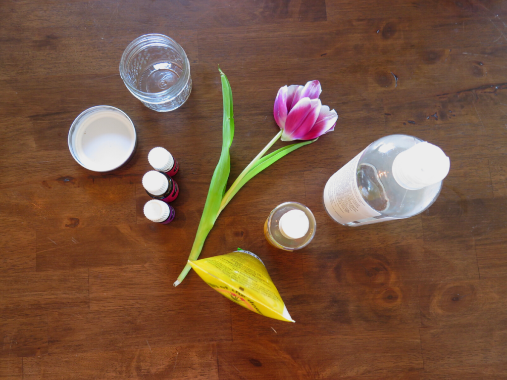 flower on wooden table surrounded by various product bottles